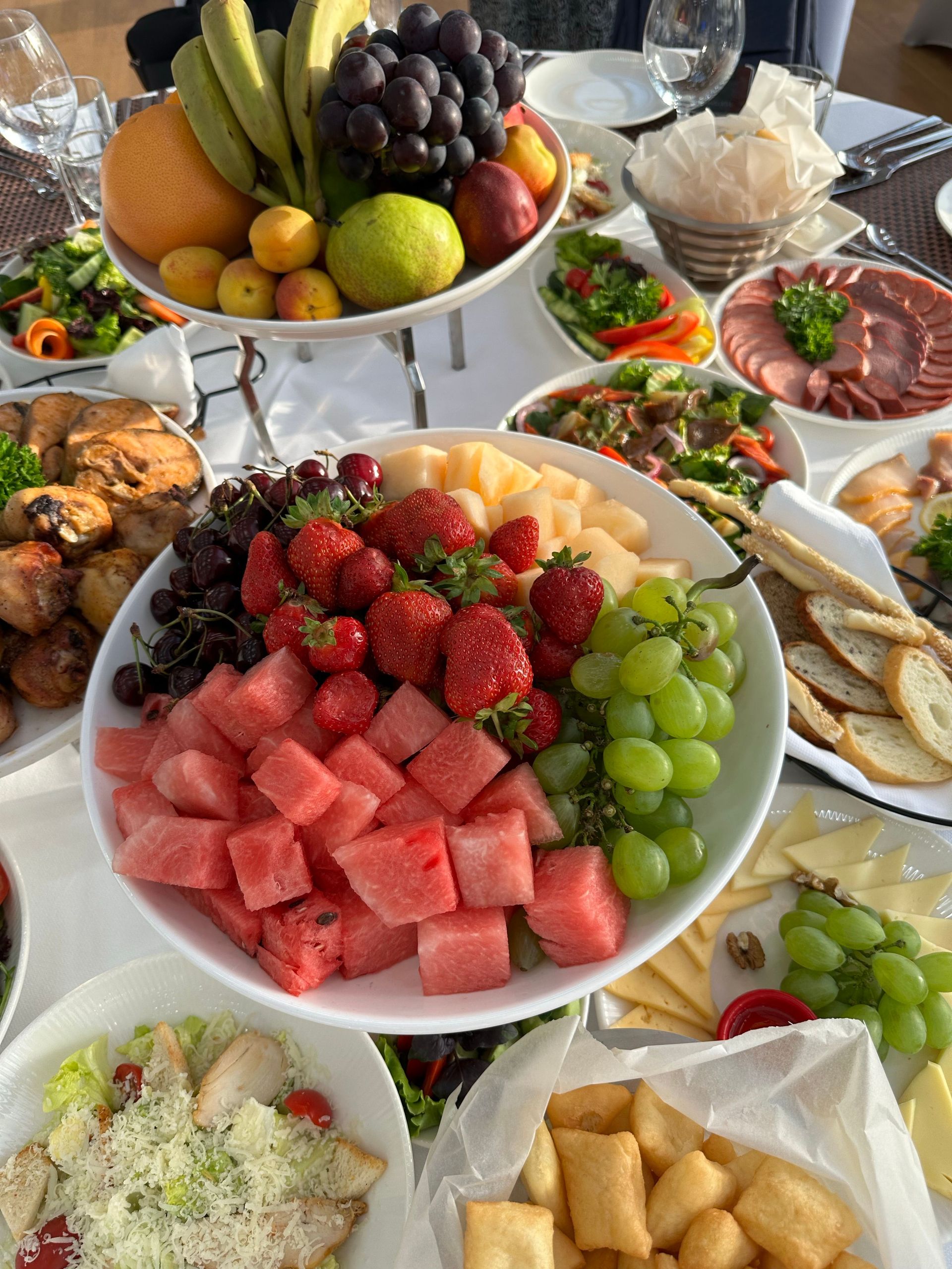 Vibrant fruit platter with appetizers on a set table in Issyk-Kul, Kyrgyzstan, embracing summer vibes.